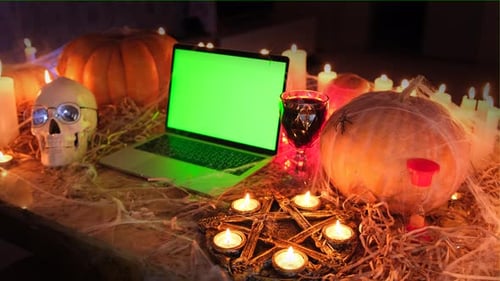 En una cripta negra y aterradora de vampiros, portátil con Chromakey en humo, velas, calabazas