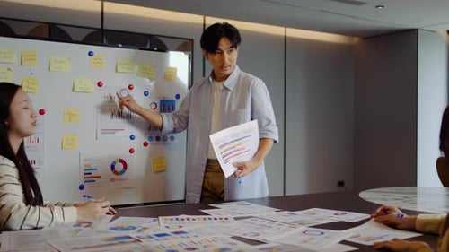 Young businessman conference passionately explains business project strategy using a whiteboard