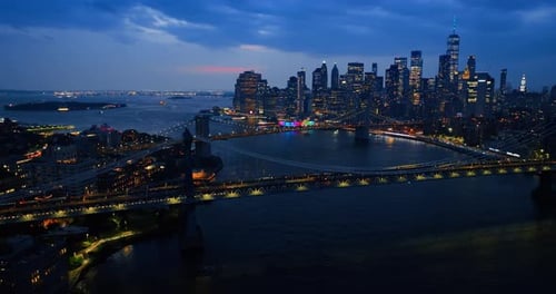 Bridges over the East River with lively traffic at night. Magnificent skyscrapers with lights