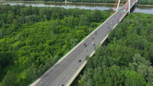 Aerial shooting from flying drone car traffic on modern highway bridge over river