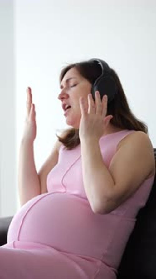 Pregnant Woman Singing Along With Headphones Indoors