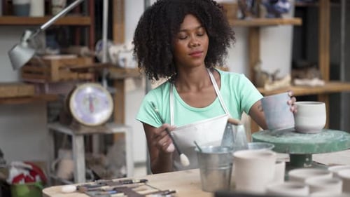 Young women is making earthenware at workshop.
