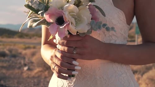 Bride Holding Bouquet in Desert During Golden Hour