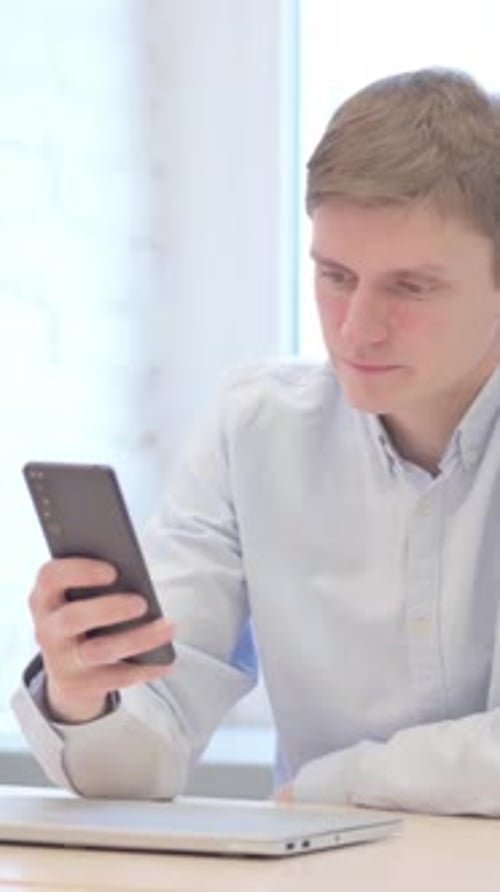 Man in Bright Room Using Mobile Phone