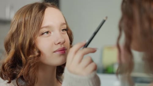Teen Girl Applying Makeup in Indoor Setting
