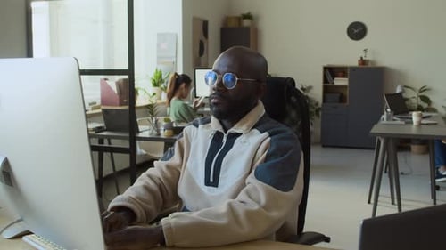 Young Adult Working at Computer in Office