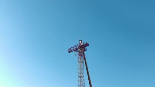 Aerial View Crane Assembly Progresses As the Operator Mounts Components and Scales Ladders Smoothly