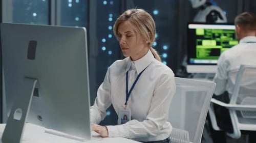 Hightech Data Center People and Robots Cooperation Young Blonde Female Assistant Working on Computer