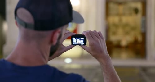Man Takes Photo With Small Camera Inside Building