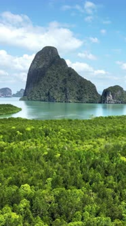 Aerial drone view of limestone karst islands rising from the sea in Phang Nga Bay, Thailand. Vertica