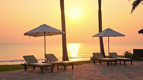 Lovely view of a golden sunset with in some tropical destination, with empty beach lounges and umbre
