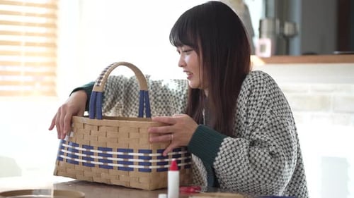 Woman showing her finished woven basket craft