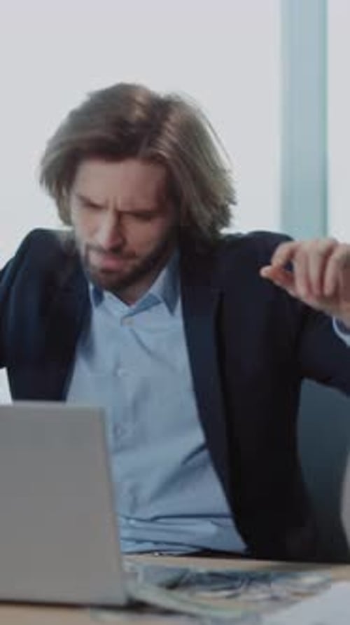 A Professional Man in a Suit Works at His Laptop Desk Showing Productivity