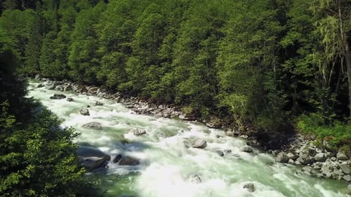 River Current Flowing in the Valley Around the Smooth Rocks During a Bright Sunny Spring Day