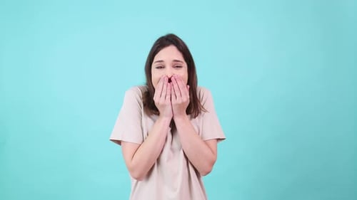 Excited Woman Celebrating with Raised Arms on Turquoise Background