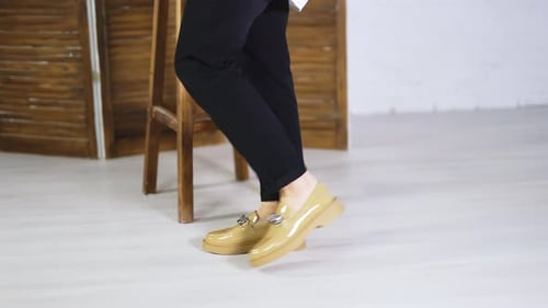 Female walking back and forth in fashionable new shoes. Beige stylish footwear on plain soles
