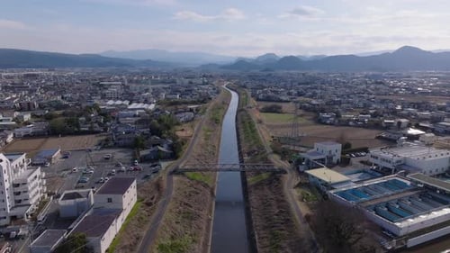 Forwards Fly Above River in Artificial Bed Flowing Through Town Cascade of Mountain Ridges in