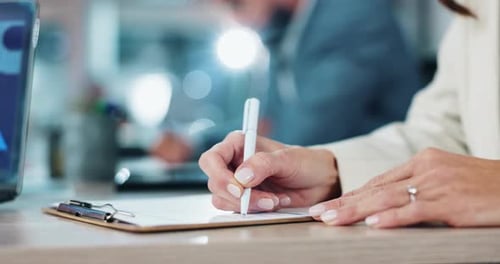 Woman Writing on Clipboard in Office Setting