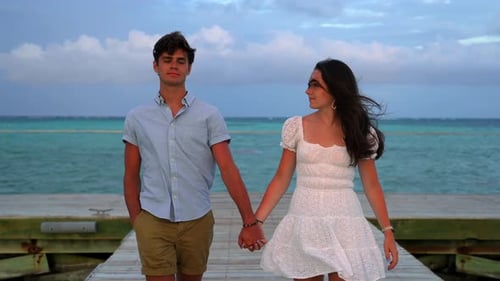 Tropical island paradise. Young couple walks hand in hand on ocean pier dock. Dating and newlywed