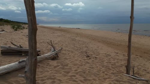 Cloudy Coastal Charm Aerial View Showcases a Sandy Beach Next to Water Under Cloudy Skies