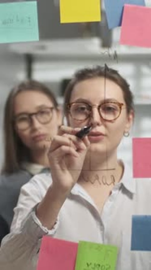 Business Women Teamwork at Clear Board in Office