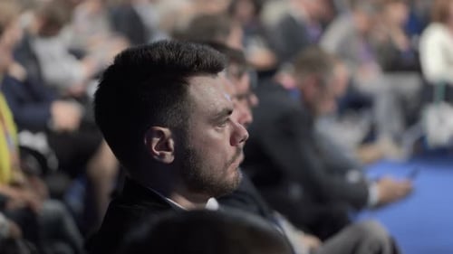 Crowded auditorium view as speaker delivers speech at corporate event
