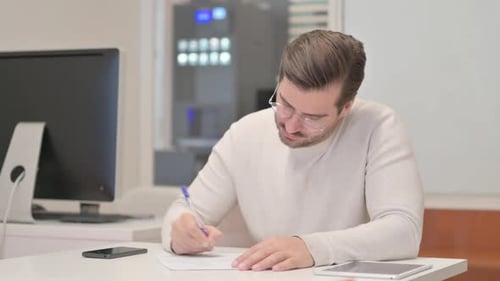 Young Man Writing a Letter in Office