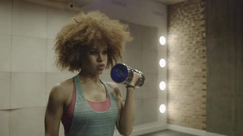 Adult woman exercising with weights in gym