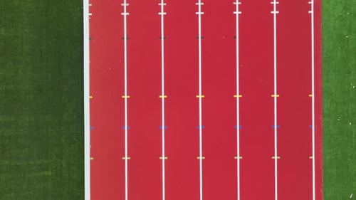 Aerial View of a Red Athletic Track and Field Area With Green Grass Surrounding It