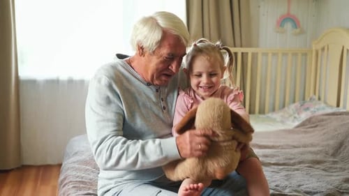 Grandfather and Granddaughter Playing Together with Stuffed Animal