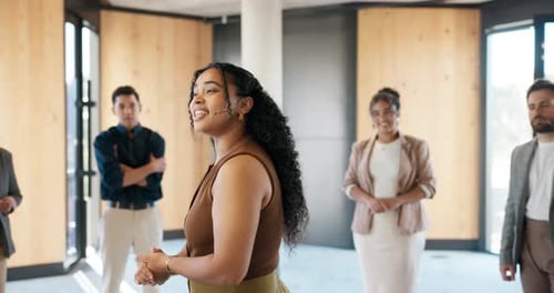 Diverse Group Listens to Woman Presenting in Modern Office