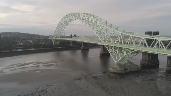 Runcorn Silver Jubilee Bridge aerial view at sunrise. Descending to low ...