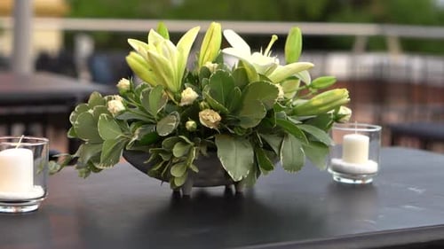 Elegant lily flower arrangement for wedding on outdoor restaurant table. Business event. Argentina.