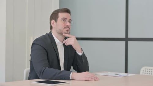 Empresário pensativo pensando enquanto está sentado no trabalho