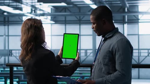 Technicians in Data Center Using Green Screen Tablet Reviewing Hardware