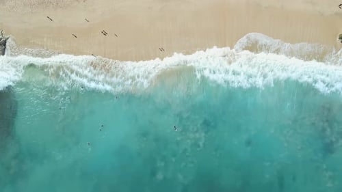 Sandy beach and turquoise ocean with waves in sunny day. Aerial view. Top view