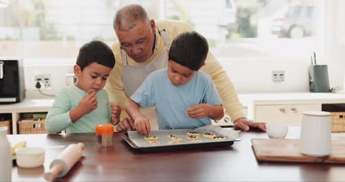 Grandfather Baking Cookies With Grandsons in Kitchen
