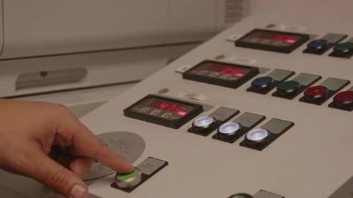Nahaufnahme von Händen, die Tasten drücken und Wählscheiben auf einem werkseitigen Bedienfeld drehen