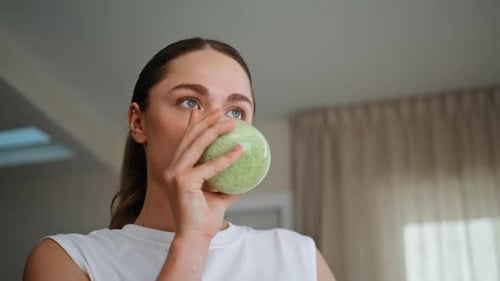 Woman Drinking Green Smoothie in Light Apartment Interior Closeup Relaxed Lady