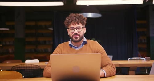 Man Video Calling with Laptop in Library