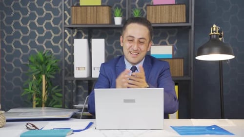 Excited Businessman Celebrating Success at Office Desk