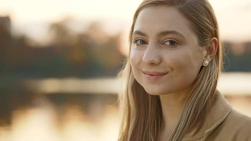 Nahaufnahme einer attraktiven kaukasischen Frau, lächelnde Dame, selbstbewusst, hübsch, die in der Nähe der Stadt steht