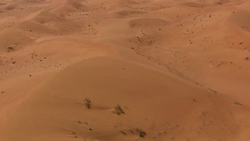 Desert dunes seen from the sky with fast motion and tilt down