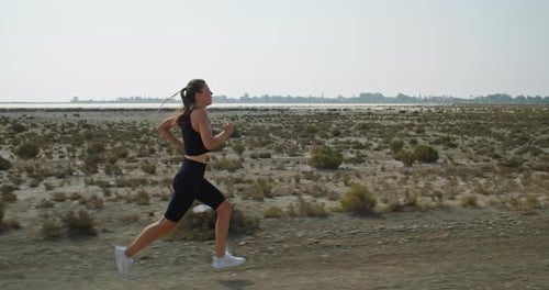 Woman Running across Rural Field
