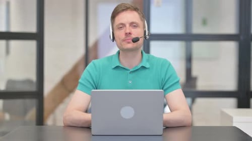 Mature Adult Man with Headset Looking at Camera in Call Center
