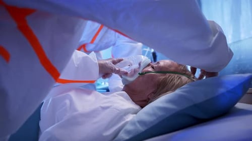 Side View Doctors and Covid-19 Patient with Oxygen Mask in Bed In