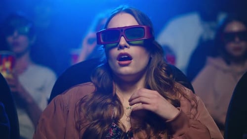 Shocked Lady Feeling Scared At Cinema. Closeup Frightened Girl Sitting In Movie Theatre. Portrait...