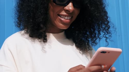 Smiling Woman Using Smartphone in City Setting