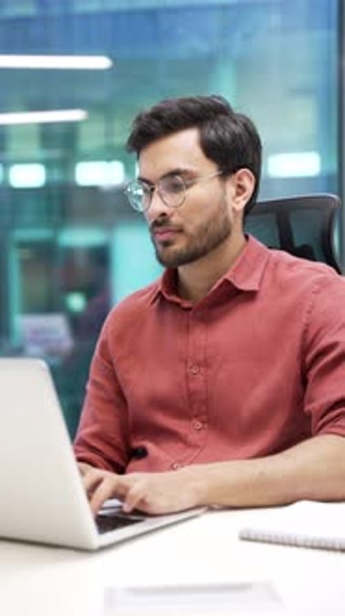 Young Man Working on Laptop in Modern Office