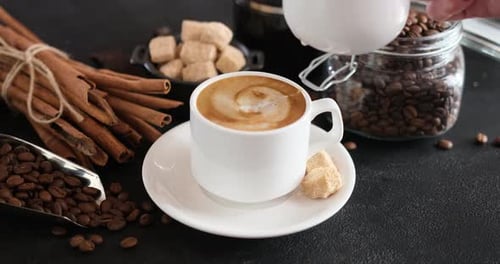 Pouring Milk Into a Cup of Coffee